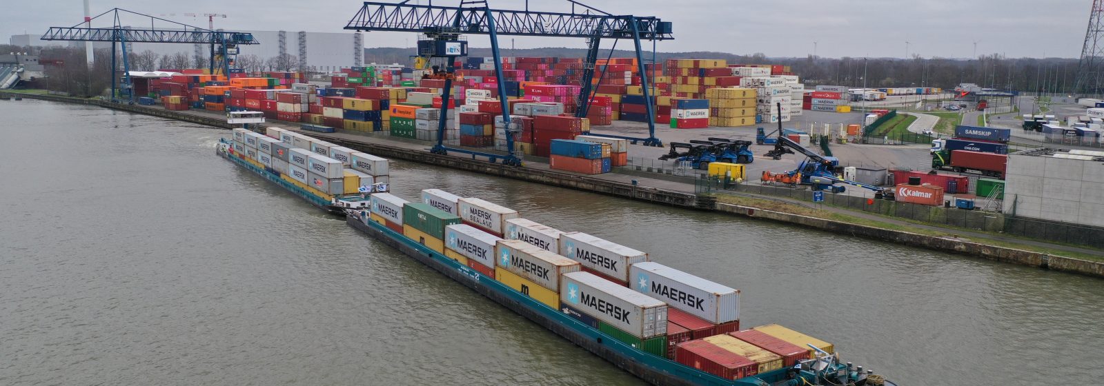 Het duwkonvooi met vier lagen containers verlaat de terminal richting Antwerpen.